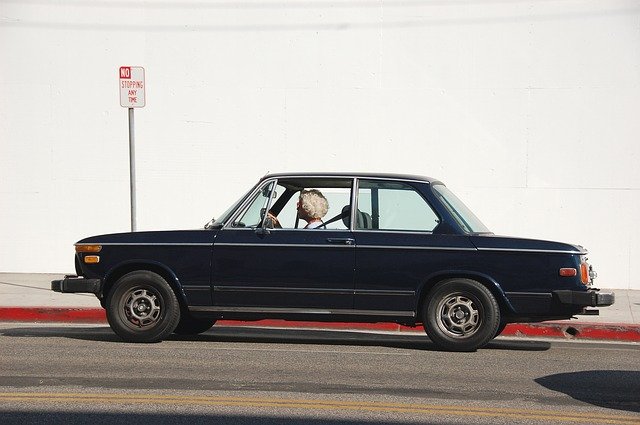 Senior lady driving a vintage car